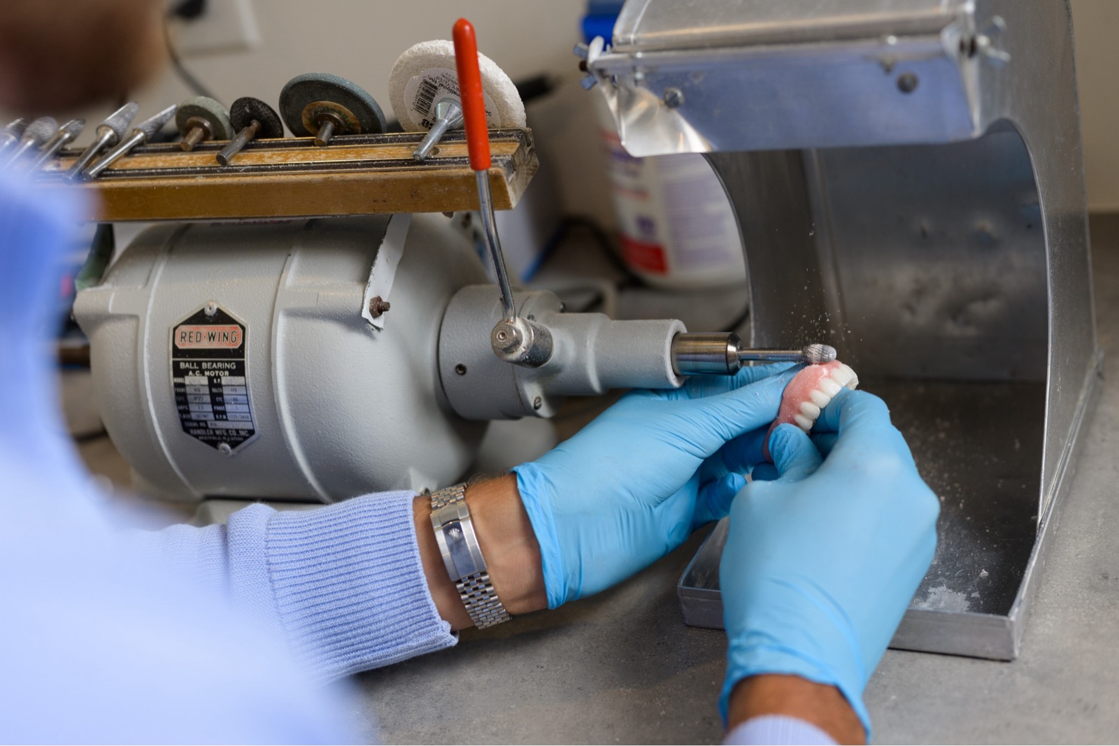 Hands carefully finishing a denture